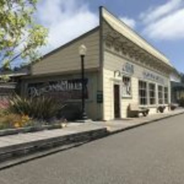 Exterior of Cape Fear Café, a light-colored building with large windows and a street lamp.