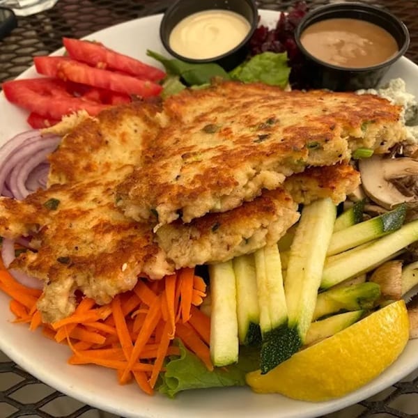 Cape Fear Café's crab cakes with sliced tomatoes, red onions, shredded carrots, zucchini, and dipping sauces.
