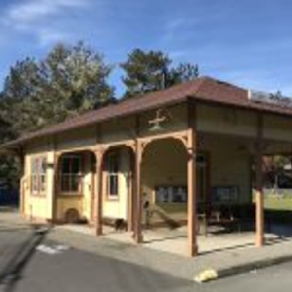 Exterior of Cape Fear Café, a light yellow building with a covered porch and brown trim.